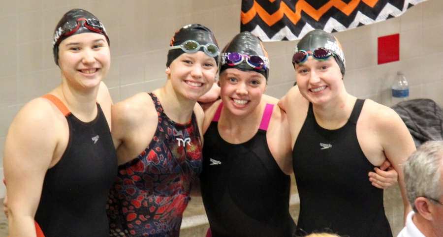four girls wearing swim caps